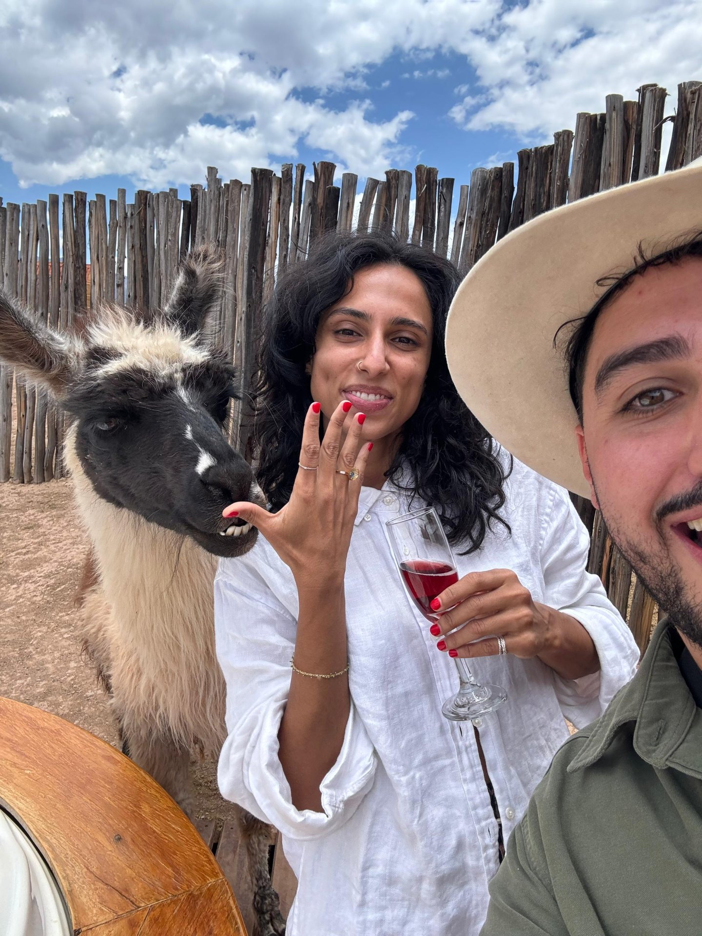 Rachel showing the engagement ring next to a llama